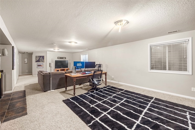 carpeted office space with a textured ceiling