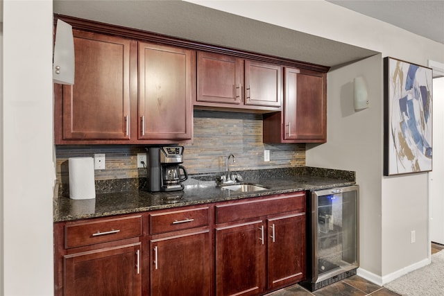 kitchen featuring dark stone countertops, wine cooler, tasteful backsplash, and sink