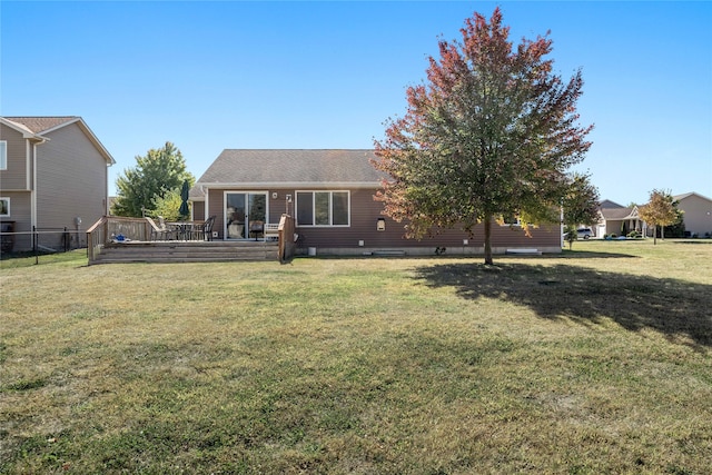 rear view of house with a deck and a yard