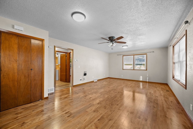 interior space featuring a textured ceiling, light hardwood / wood-style floors, and ceiling fan