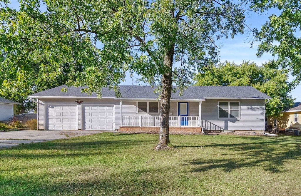 single story home featuring a front lawn, a porch, and a garage