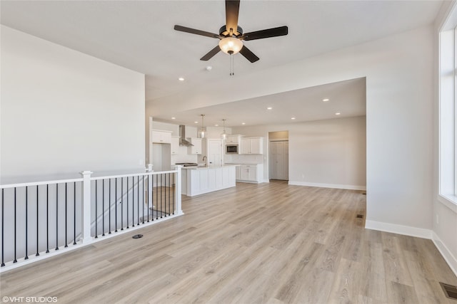 unfurnished living room featuring light hardwood / wood-style floors and ceiling fan