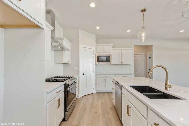 kitchen featuring sink, hanging light fixtures, light stone countertops, stainless steel appliances, and white cabinets