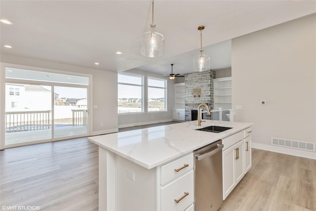 kitchen featuring light stone countertops, white cabinets, sink, a kitchen island with sink, and stainless steel dishwasher