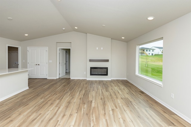 unfurnished living room with light hardwood / wood-style floors and vaulted ceiling