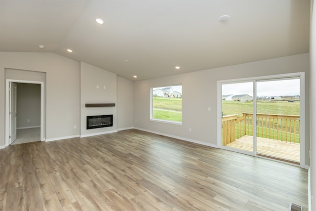 unfurnished living room featuring light hardwood / wood-style flooring and vaulted ceiling