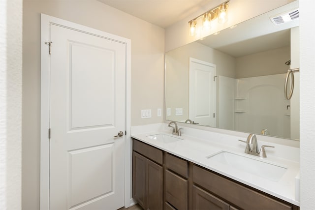 bathroom with walk in shower and vanity