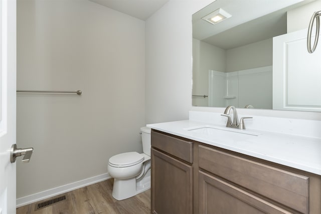 bathroom with toilet, vanity, and hardwood / wood-style flooring