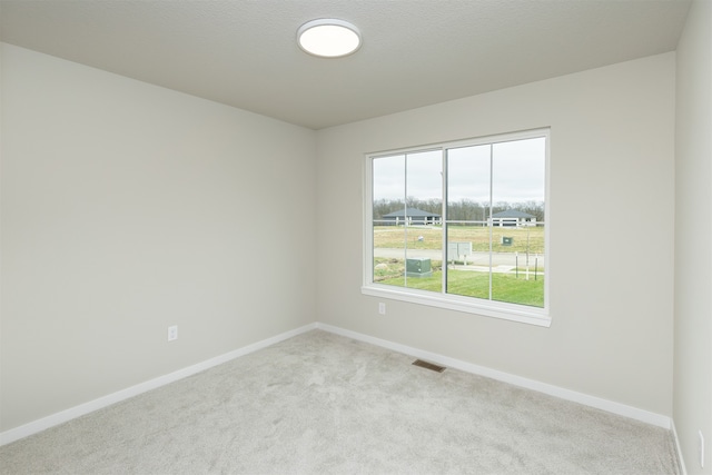 carpeted spare room featuring a textured ceiling