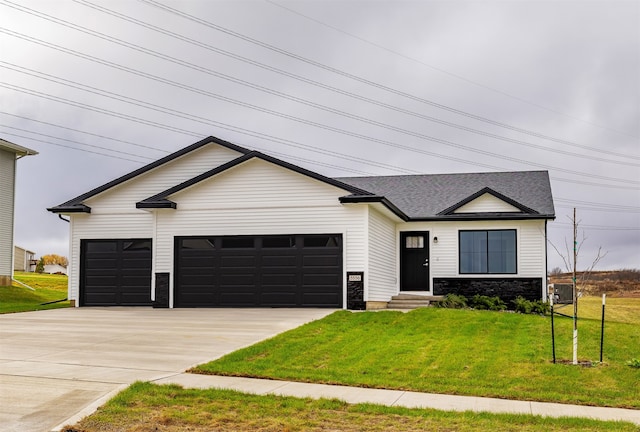 view of front facade featuring a garage, a front yard, and central AC