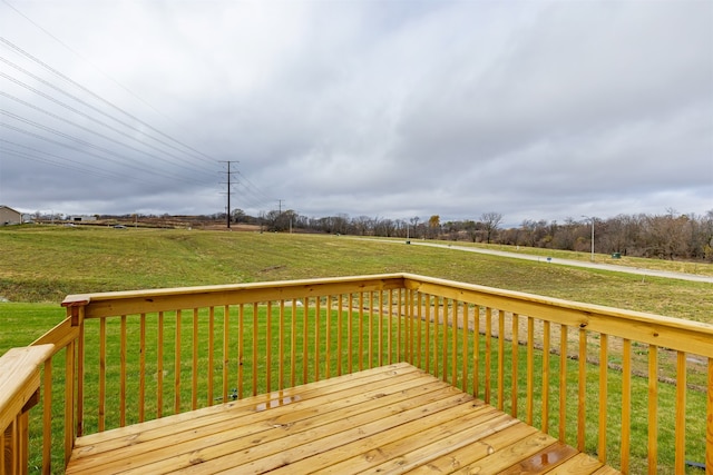 deck with a rural view and a lawn