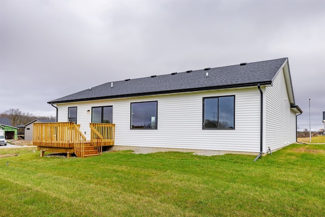 rear view of property featuring a lawn and a wooden deck