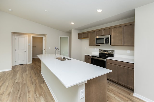 kitchen featuring a kitchen island with sink, light hardwood / wood-style floors, stainless steel appliances, and sink