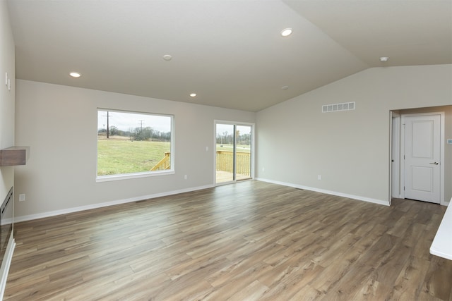 unfurnished living room featuring light hardwood / wood-style floors and vaulted ceiling