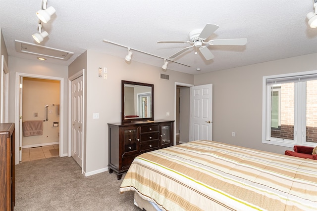 bedroom with a textured ceiling, ceiling fan, light carpet, and ensuite bathroom