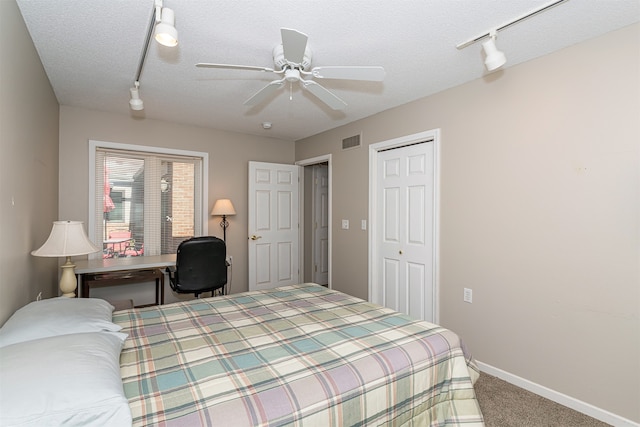 carpeted bedroom featuring a closet, ceiling fan, and a textured ceiling