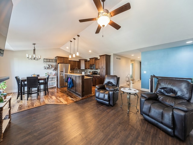 living room with lofted ceiling, dark hardwood / wood-style flooring, ceiling fan with notable chandelier, and sink