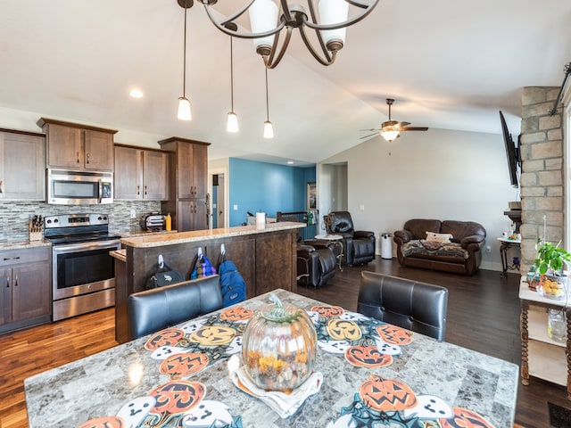 dining area featuring ceiling fan with notable chandelier, dark hardwood / wood-style floors, and lofted ceiling