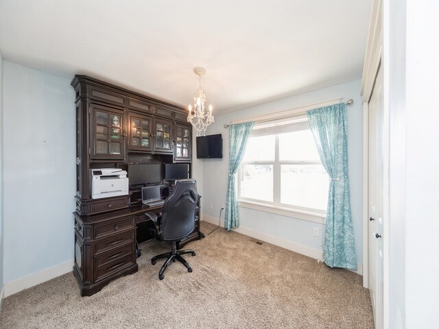 carpeted home office with an inviting chandelier