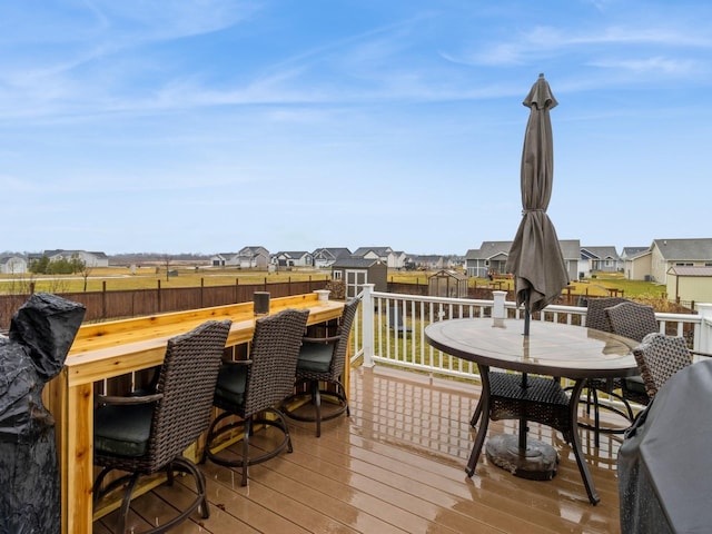 deck featuring exterior bar and a storage unit