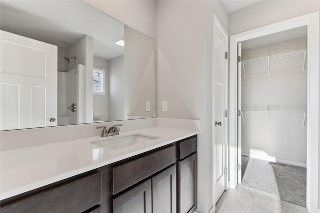 bathroom featuring walk in shower and vanity