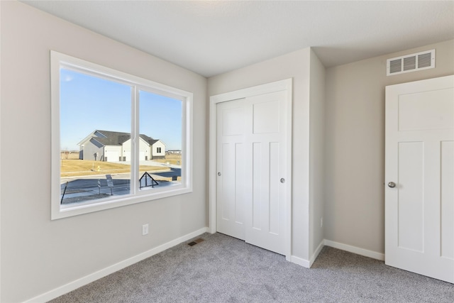 unfurnished bedroom featuring light carpet and a closet