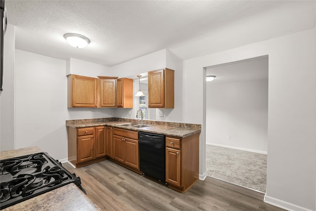 kitchen with a textured ceiling, dark hardwood / wood-style flooring, sink, and black appliances