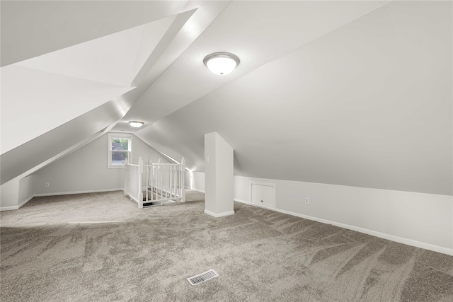 bonus room with carpet floors and vaulted ceiling