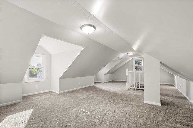 bonus room featuring carpet flooring and vaulted ceiling