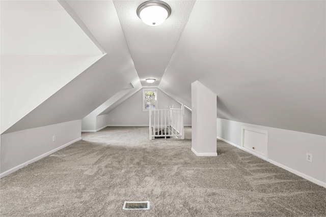 bonus room with lofted ceiling and carpet floors