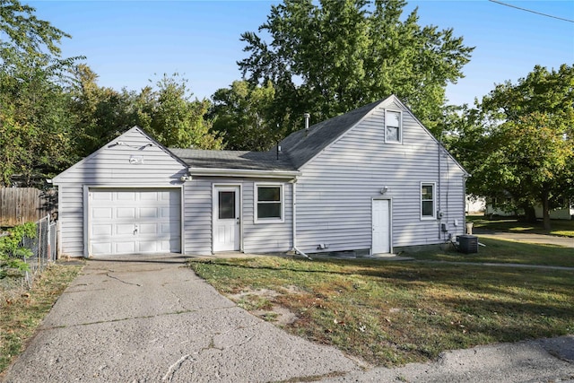 view of front of home featuring central air condition unit, a garage, and a front yard