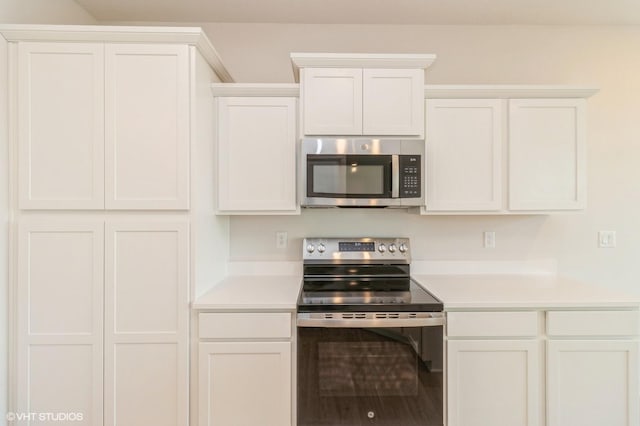 kitchen with white cabinetry, appliances with stainless steel finishes, and light countertops