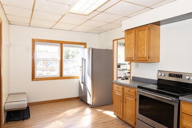 kitchen featuring light wood-type flooring, stainless steel appliances, and a paneled ceiling