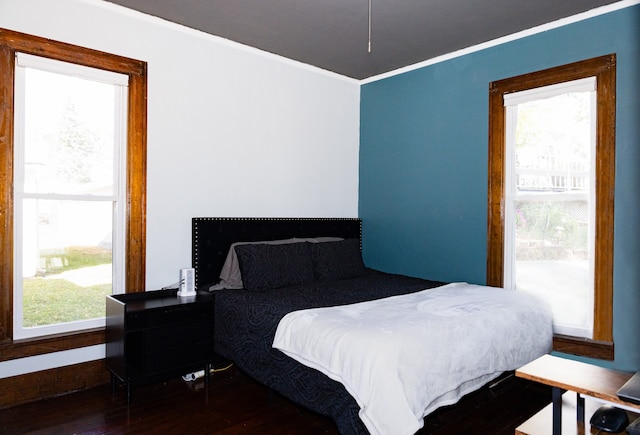 bedroom with dark wood-type flooring and multiple windows