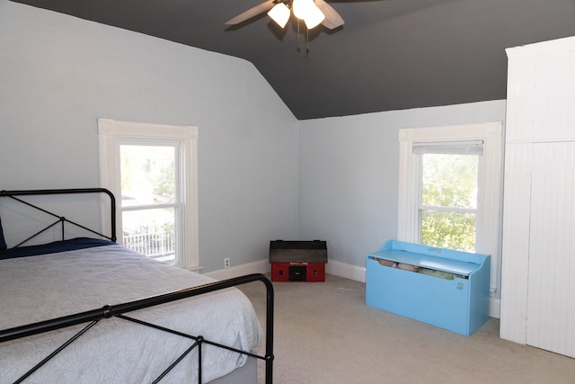 carpeted bedroom with ceiling fan and vaulted ceiling