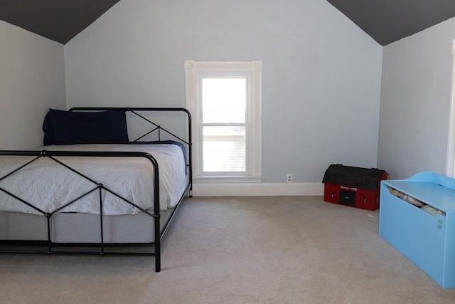 bedroom with light colored carpet and vaulted ceiling