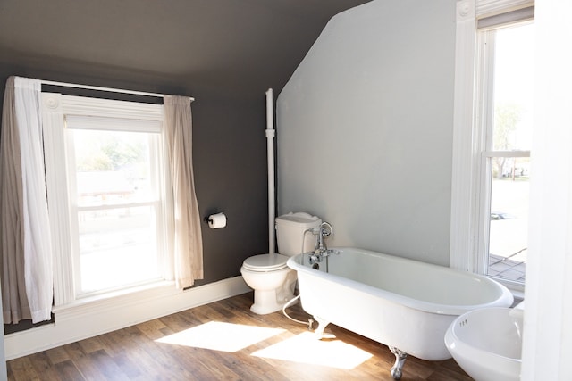 bathroom featuring hardwood / wood-style flooring, toilet, and a bathing tub