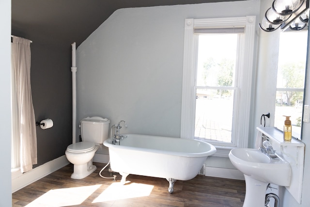 bathroom featuring hardwood / wood-style floors, toilet, plenty of natural light, and a tub