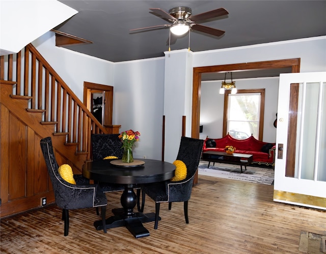 dining area featuring crown molding, hardwood / wood-style floors, and ceiling fan with notable chandelier