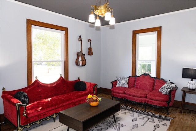 living room with hardwood / wood-style floors, crown molding, and a chandelier