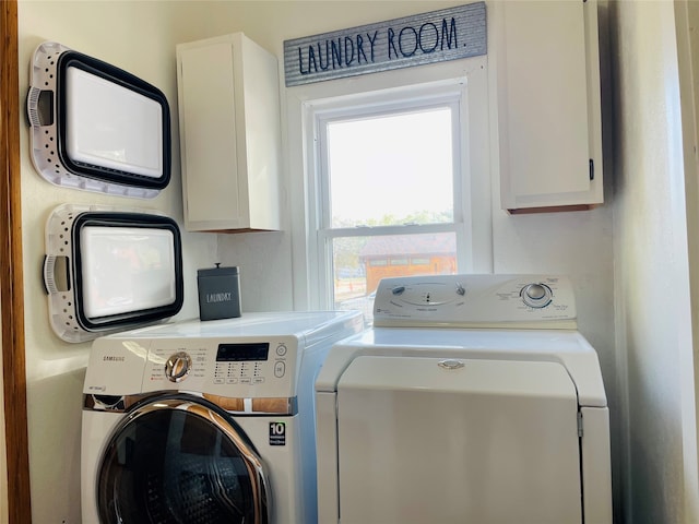 laundry area with washer and clothes dryer and cabinets