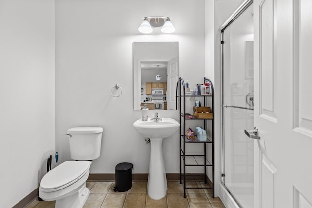 bathroom featuring tile patterned flooring, toilet, and walk in shower