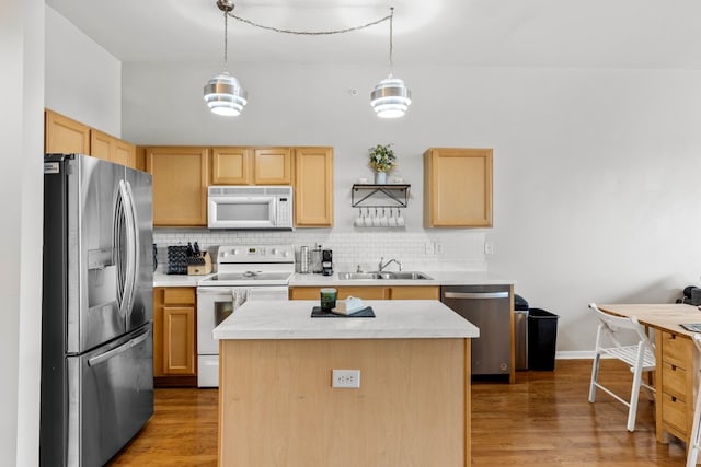 kitchen featuring a center island, hanging light fixtures, stainless steel appliances, wood-type flooring, and decorative backsplash