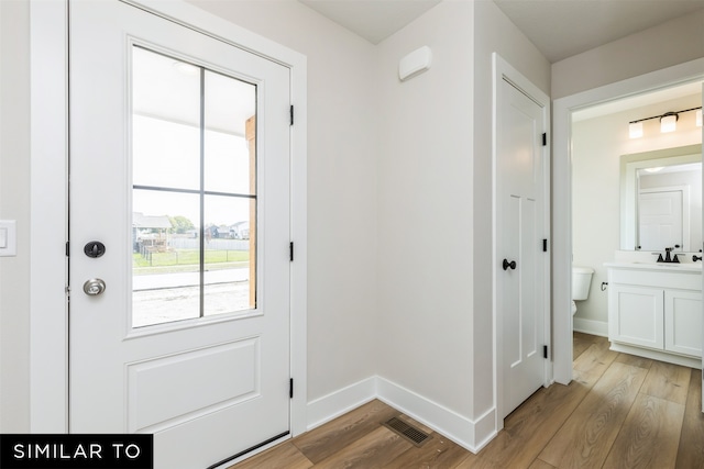 entryway featuring sink and light wood-type flooring