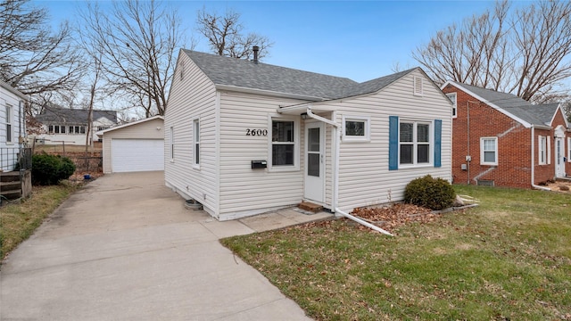 view of front of home featuring an outbuilding, a garage, and a front yard