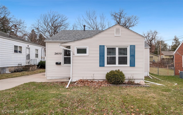 bungalow-style home featuring central air condition unit and a front lawn