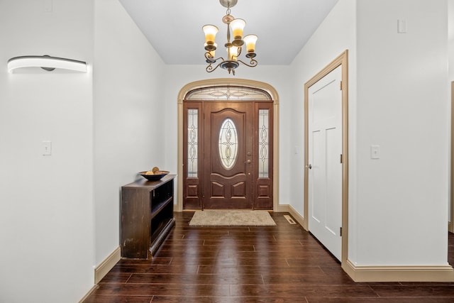 foyer entrance featuring an inviting chandelier and dark hardwood / wood-style floors