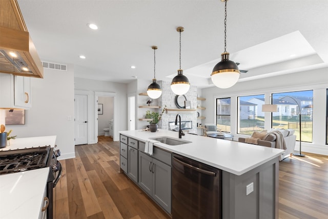 kitchen featuring stainless steel dishwasher, gas range oven, dark wood-type flooring, sink, and gray cabinets