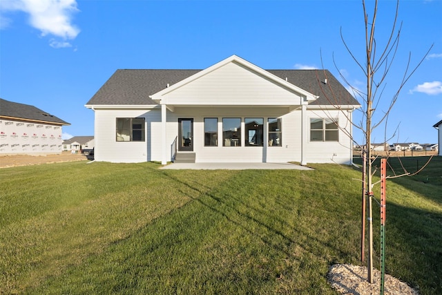 rear view of property featuring a yard and a patio