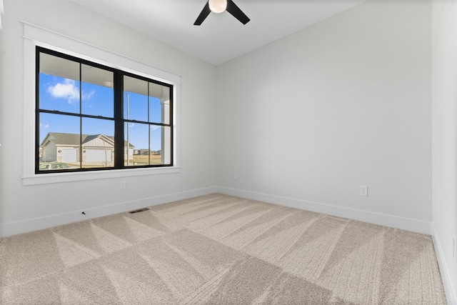 carpeted spare room featuring ceiling fan